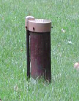 common well head in the middle of green grass