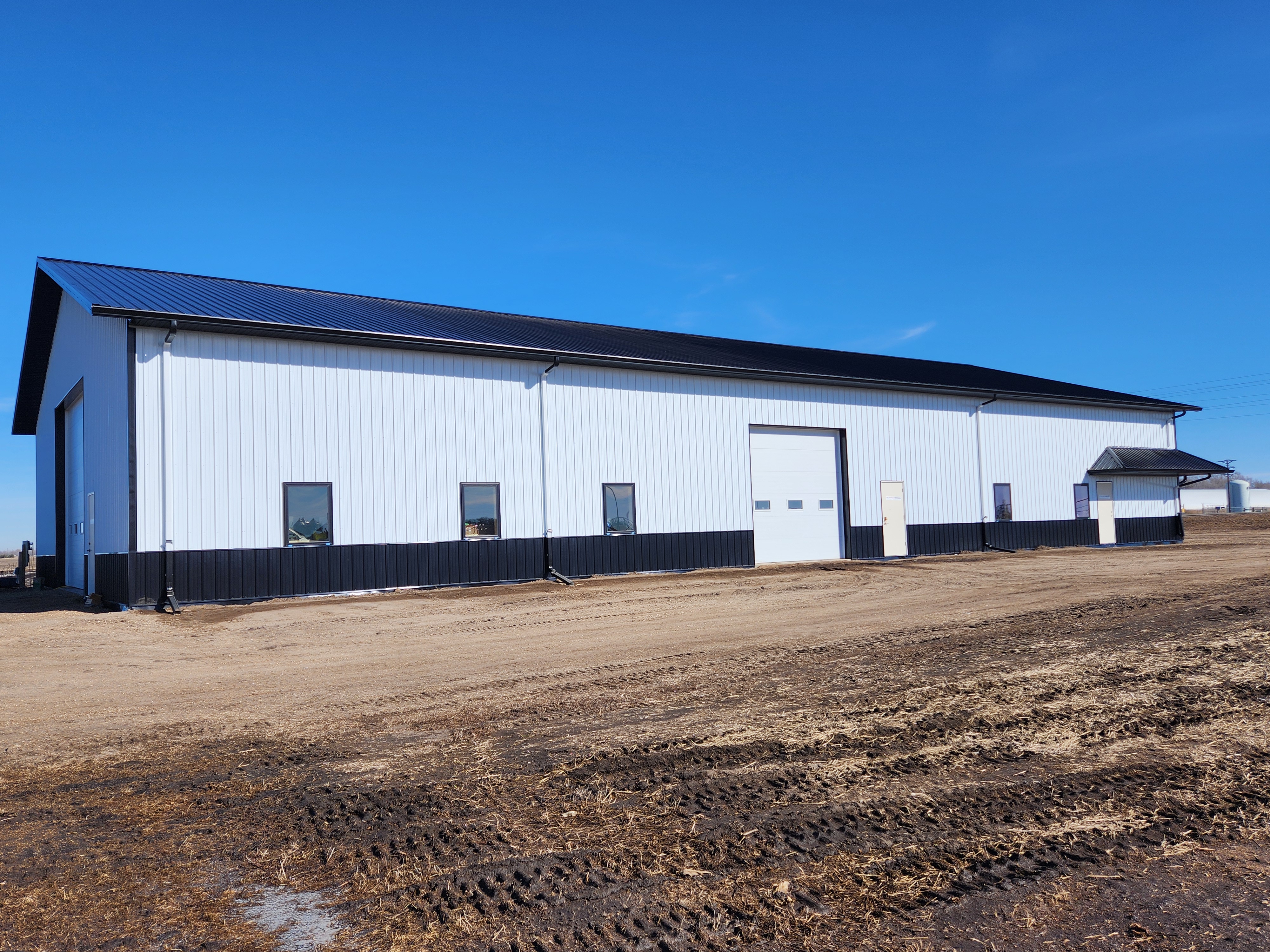 A 65x120-foot steel building with black wainscotting, white side walls, and a black roof stands on a gravel yard at the 线上赌博app Oakes Irrigation Site.