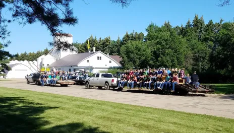 Tour wagons filled with people wait to leave the Carrington Research Extension Center for morning tours at Field Day.