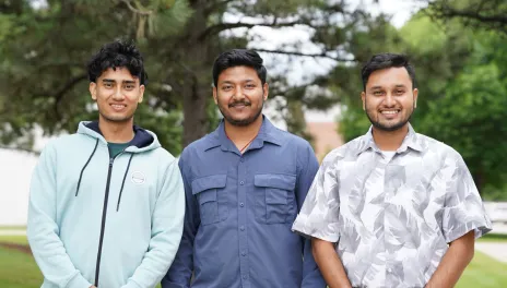 Three men standing outdoors.