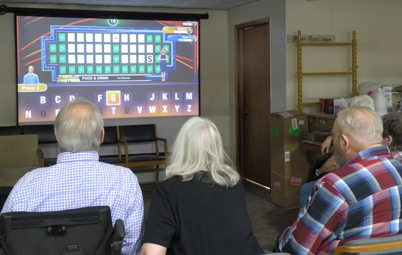Senior citizens playing Wheel of Fortune game on TV