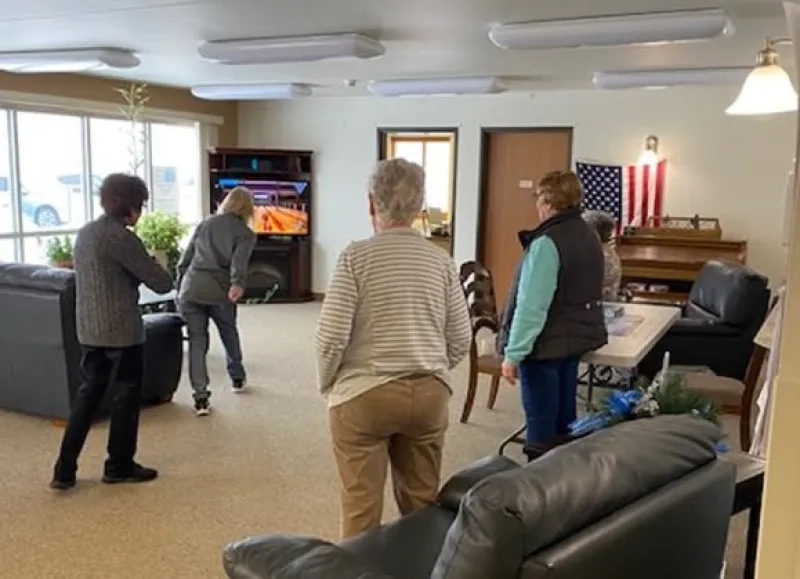 4 elderly people do virtual bowling on at TV