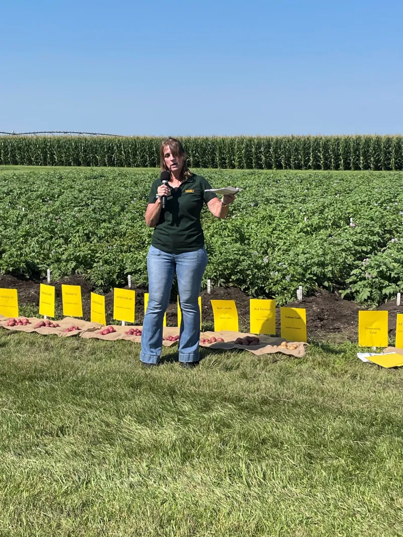 Asunta Thompson giving a presentation in a field