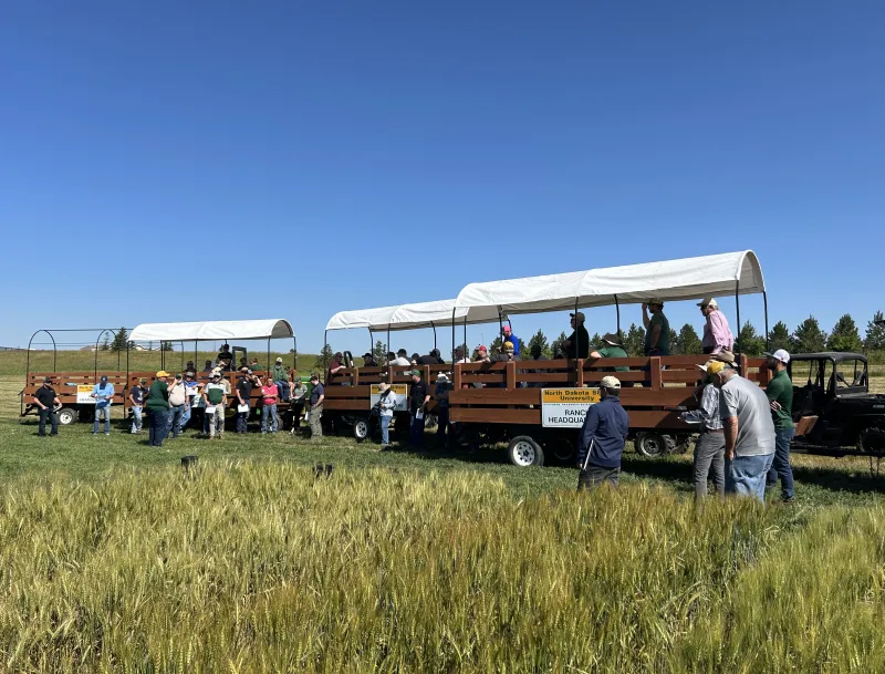 people on covered wagons taking agronomy tour