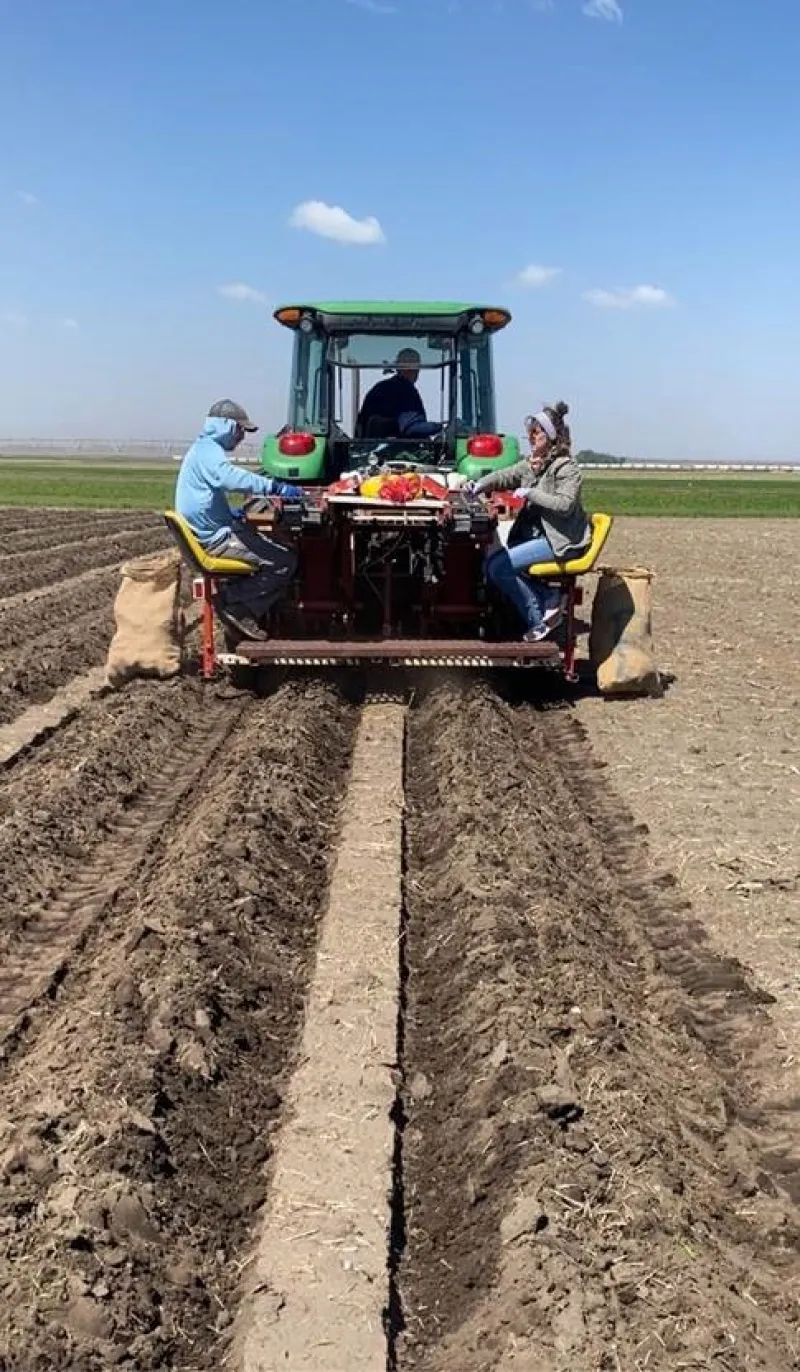 two people behind a tractor doing research
