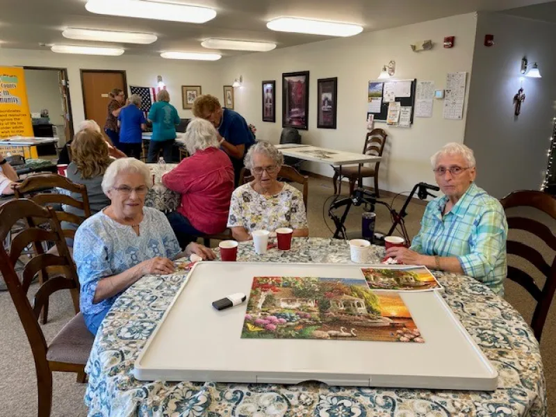 three senior citizens with their finished puzzle