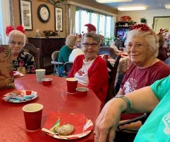 elderly women enjoying treats at a table at a Christmas party