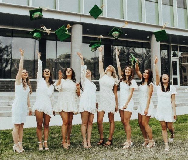 Students pose in front of campus building
