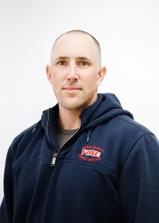 A man in a hoodie grinning