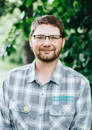 A man with glasses smiles