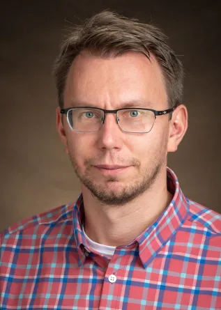 Alexey Leontyev smiling confidently at the camera