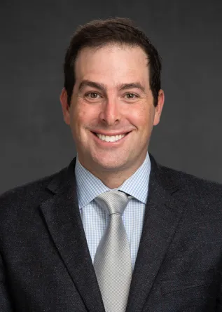 Adam Goldwyn smiling confidently at camera.