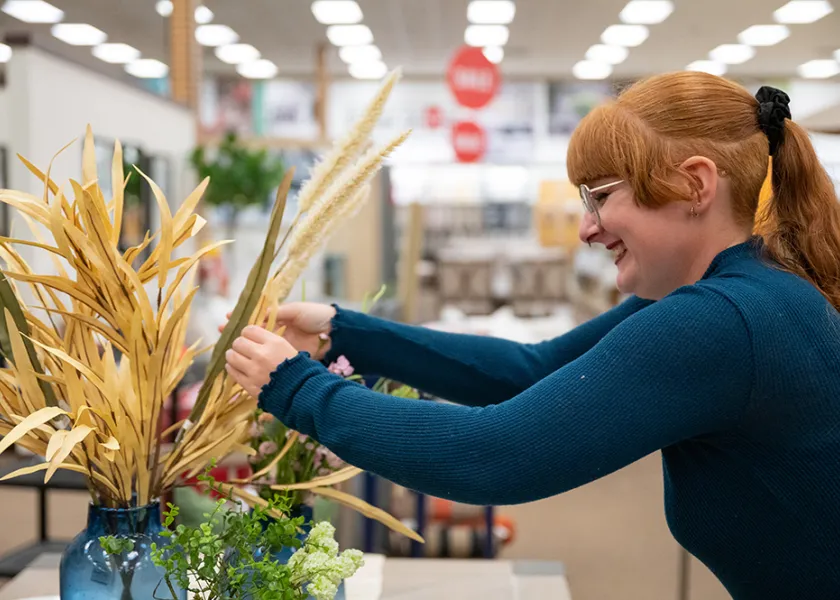 an 线上赌博app student works on a flower arrangement as part of a project