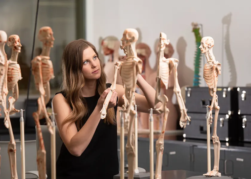 student inspecting skeleton