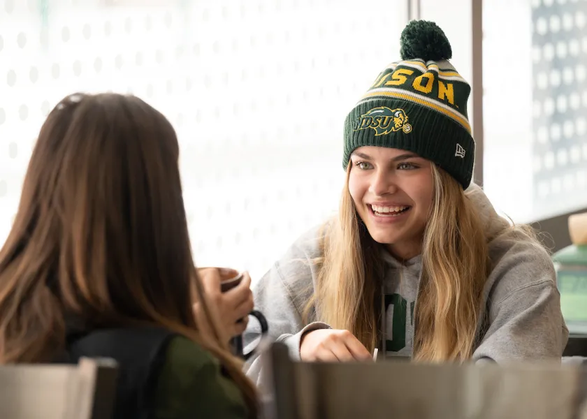 Photo of 线上赌博app students talking in dining center