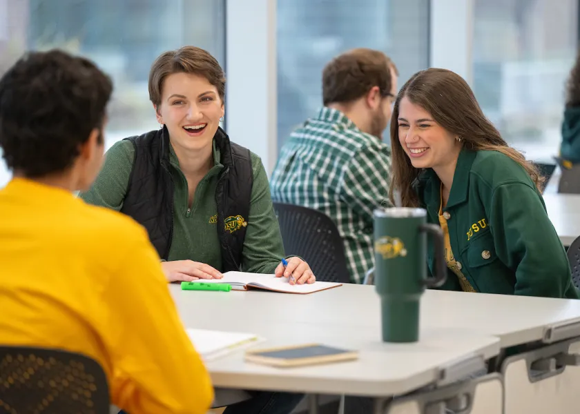 线上赌博app Students talking and studying at table