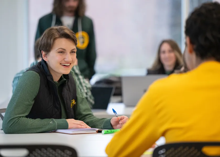 线上赌博app Students talking and studying at table
