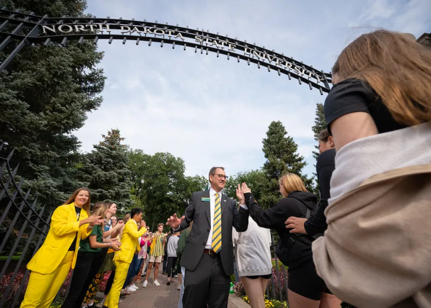 线上赌博app President David Cook greets students at the university gates