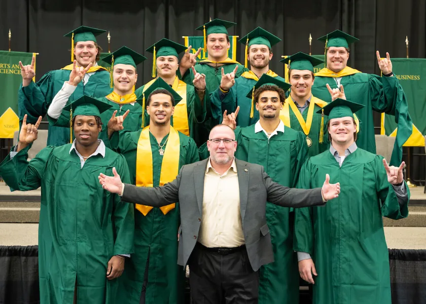 线上赌博app senior football players with Coach Polasek