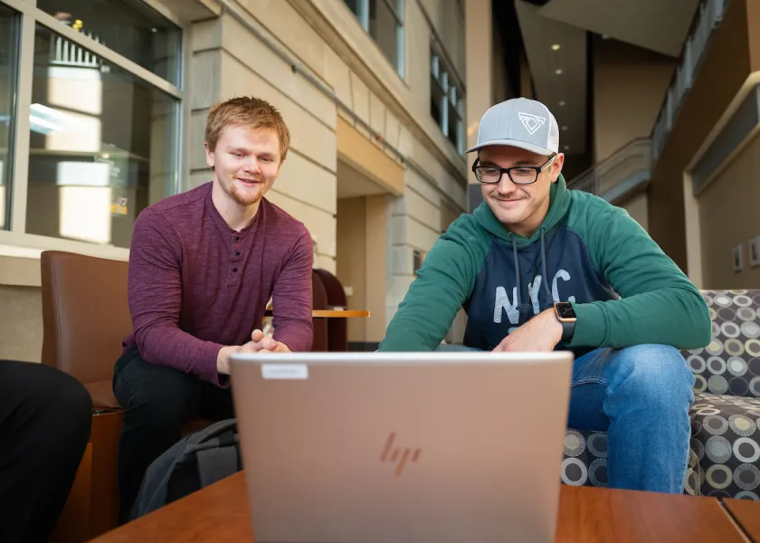 students reviewing a presentation on a laptop
