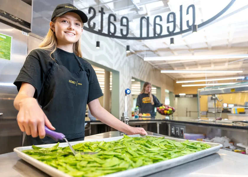 线上赌博app Dining employee prepares food in the Clean Eats Station