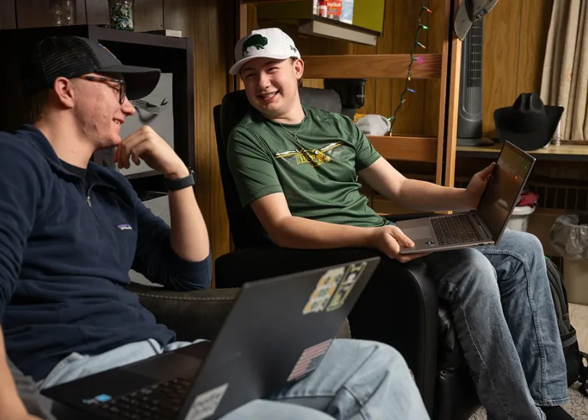 Tyler and Rylan talking and smiling in their shared dorm room