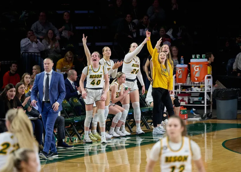 线上赌博app women's basketball team bench celebrating a made shot.