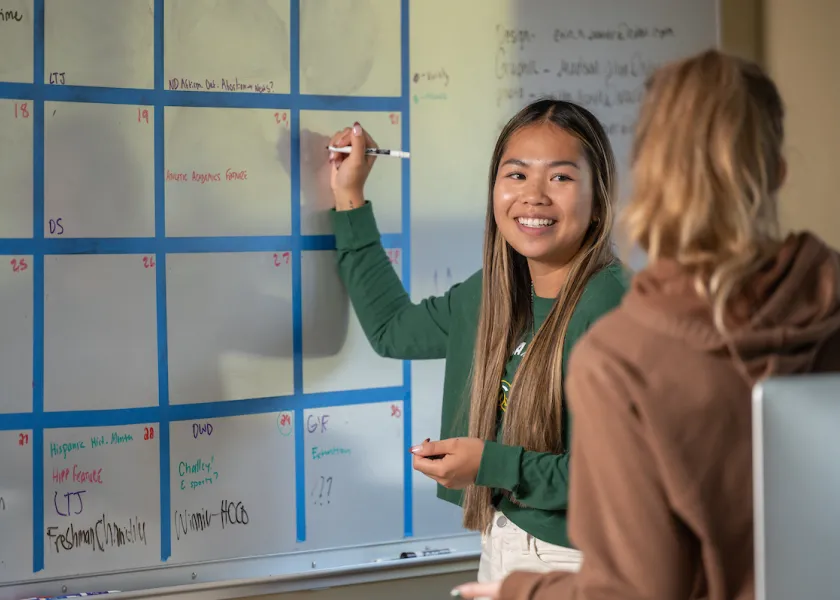 communication students creating a schedule on a whiteboard