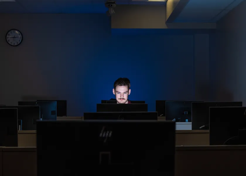 student working in a dark computer lab