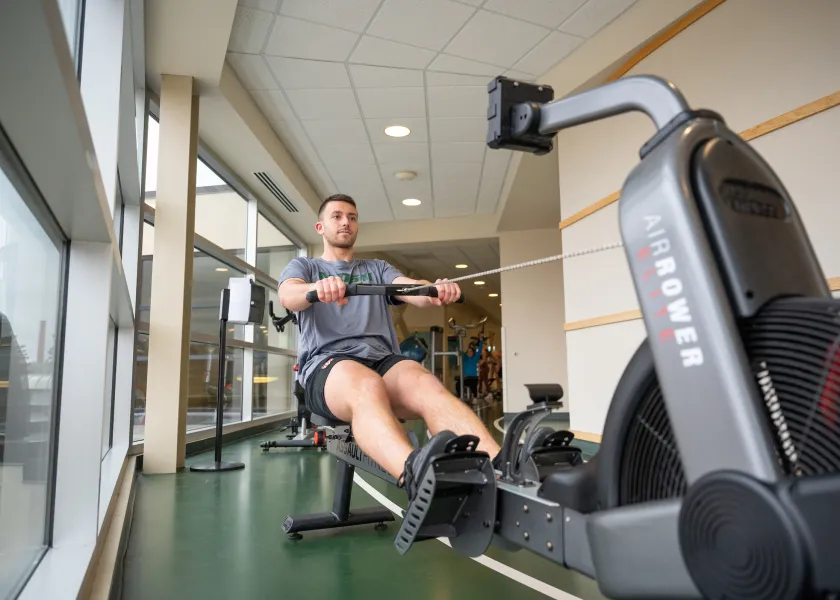 student exercising on a rowing machine