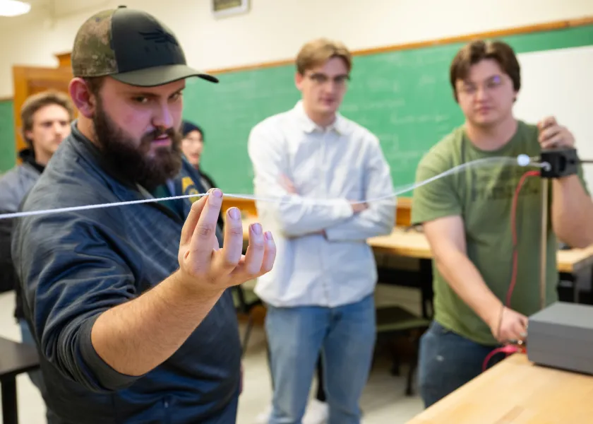 students performing a physics experiment in a classroom