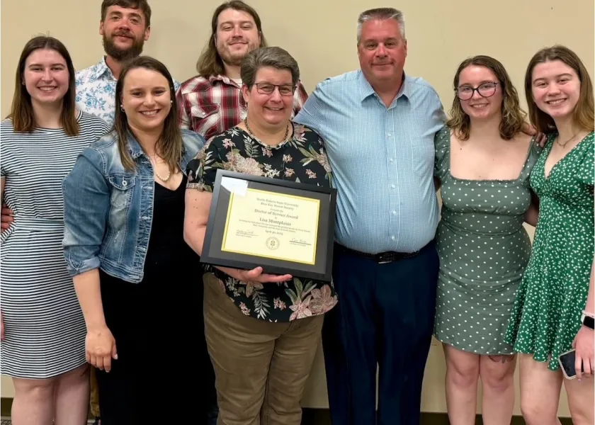 Lisa Montplaisir, 线上赌博app professor of biological sciences, holding her award while standing with members of 线上赌博app's Blue Key Honor Society