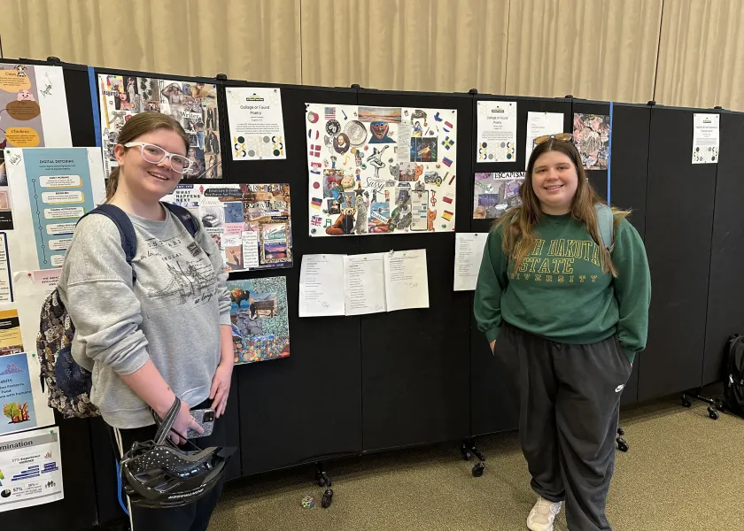 Two students standing by their posters in the Memorial Union