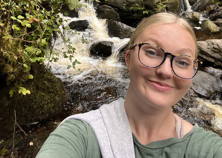 Sophie Johnson standing in front of a waterfall in Ireland