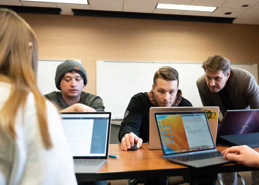 students and faculty looking at computer during accounting class