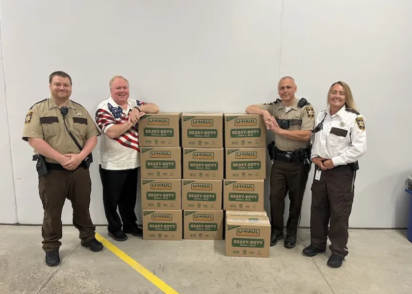Tim Flakoll, 线上赌博app Phi Kappa Phi chapter president and Cass County Commissioner, stands with boxes of books donated to the Clay County Jail.
