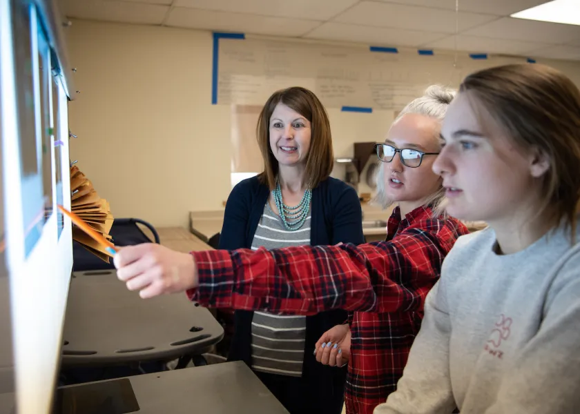 students and professor looking at xrays in the vet tech program