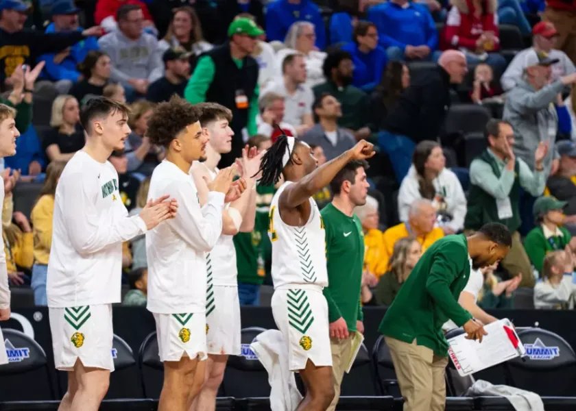 线上赌博app men's basketball players celebrate on the bench.