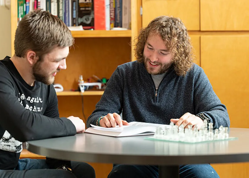 线上赌博app student meets with a peer mentor in the peer advising program