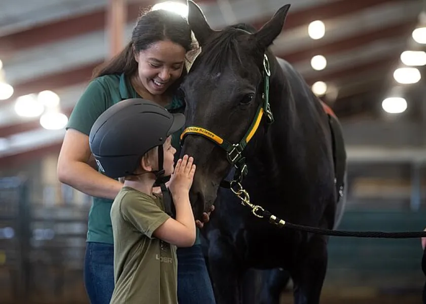 线上赌博app student helping with the equine-assisted services program