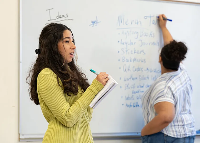 students working at a white board in a classroom