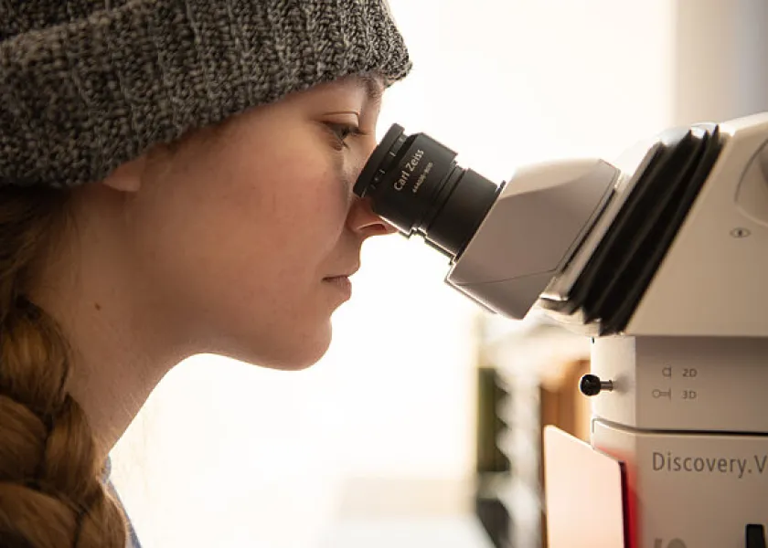 student looking at samples under a microscope