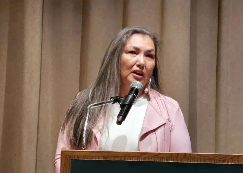 Sheridan McNeil speaking at a podium.