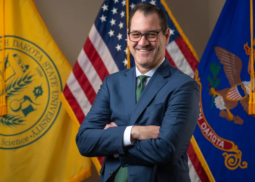President Cook in front of the flags in Old Main