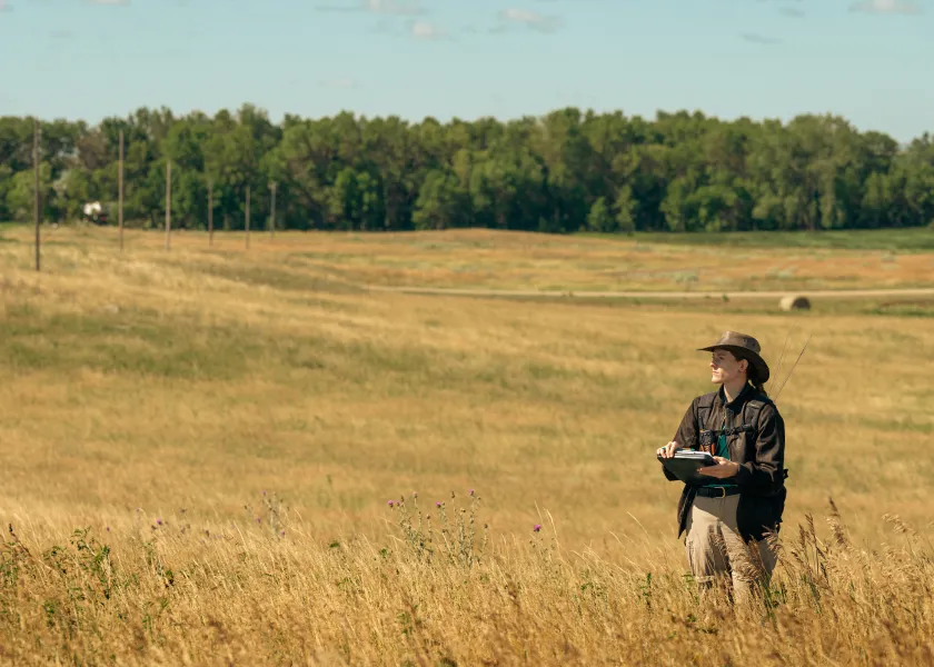 student in the field studying monarch butterflies