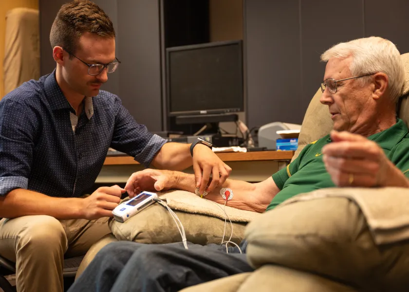 student doing research on a participant in the Healthy Aging Lab