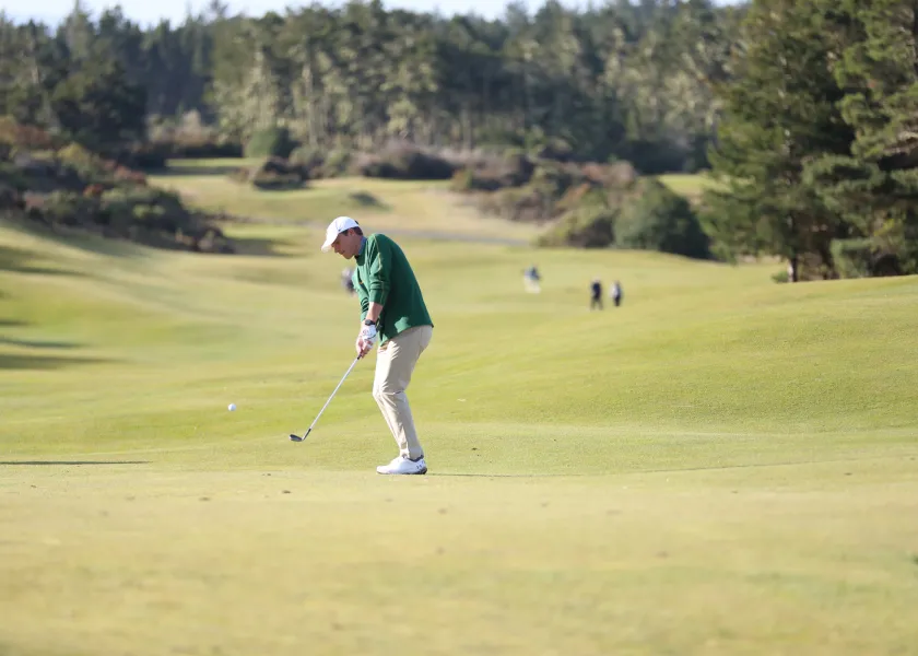 men's golf player on the course about to putt