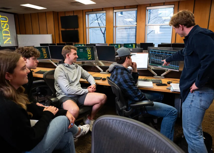 students in the College of Business work together on a computer