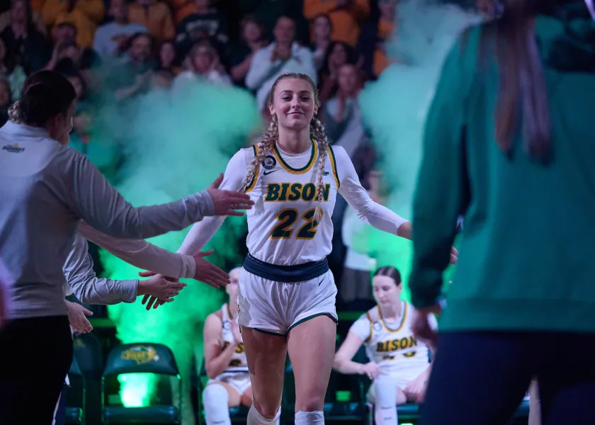 women's basketball slaps teammates hands on her way onto the court