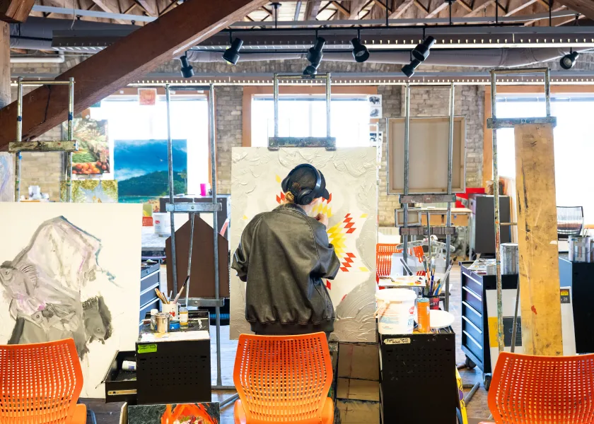 art student works on a painting in a art studio classroom